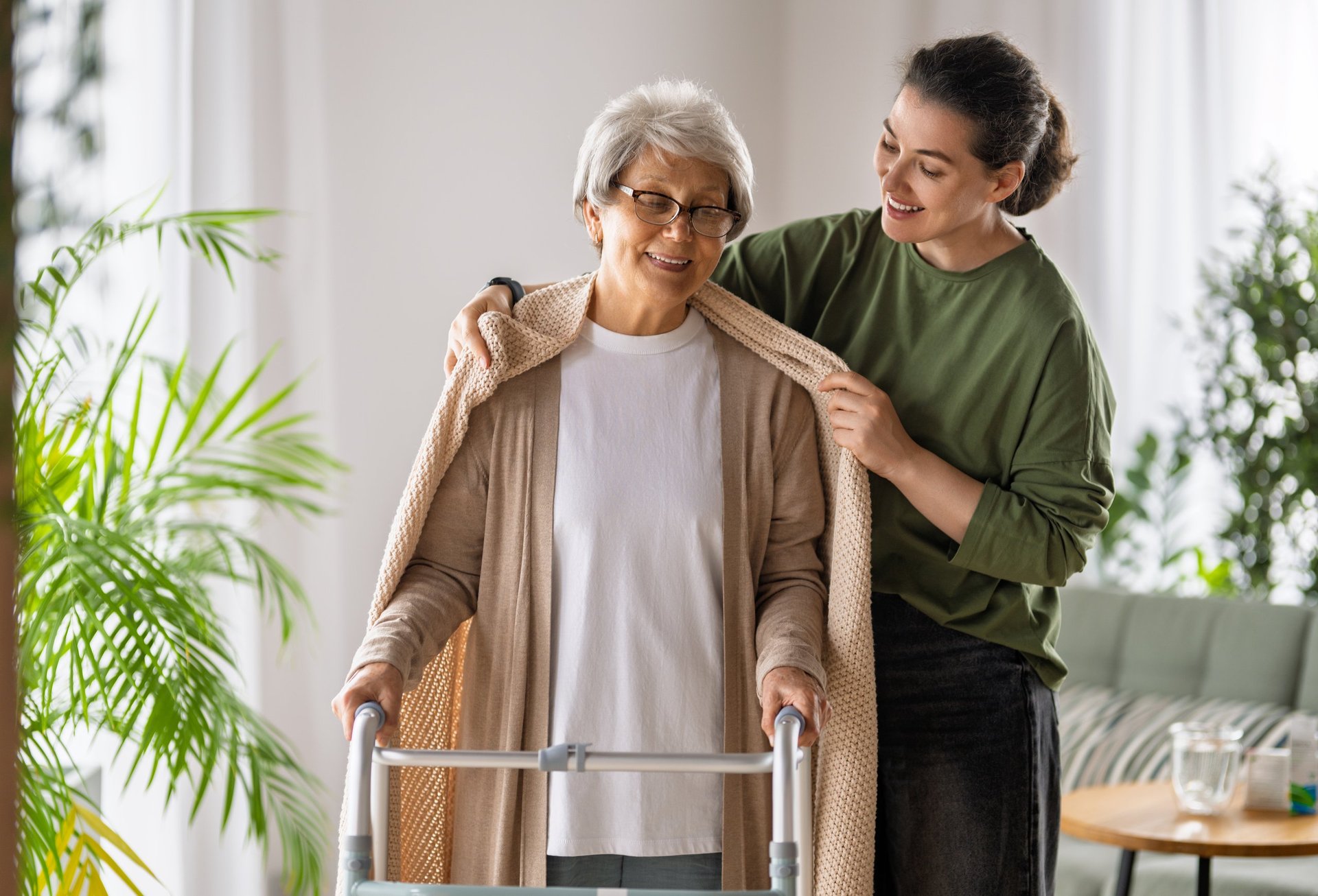 Compassionate caregiver assisting an elderly woman at home for a comfortable senior care moment
